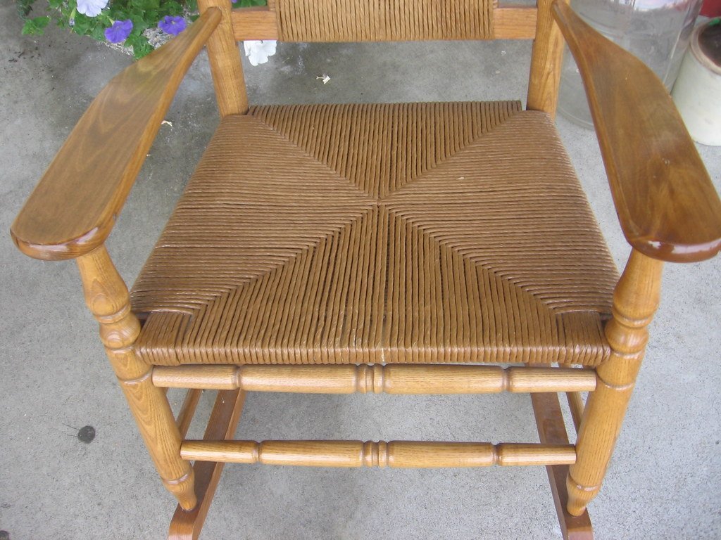 Assise de fauteuil à bascule en bois tressée en fibre torsadée, dont le tressage forme quatre triangles se rejoignant au centre
