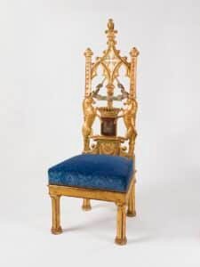Chaise néogothique en bois doré à haut dossier ajouré en arc brisé, pinacles, deux licornes cabrées encadrant un écu couronné, assise recouverte de velours bleu, réalisée par Jacob pour le cabinet gothique de la comtesse d'Osmond